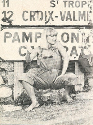 Kim Weiss's Scandinavian Backgammon Club's future secretary 'Brigitte Bardot look-alike'-Ingelise Jantzen sitting by a signpost pointing towards Saint-Tropez.
